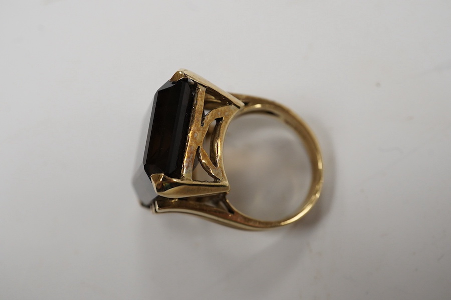 A 9ct and large single stone emerald cut smoky quartz set dress ring, size P, gross weight 14.9 grams. Condition - good